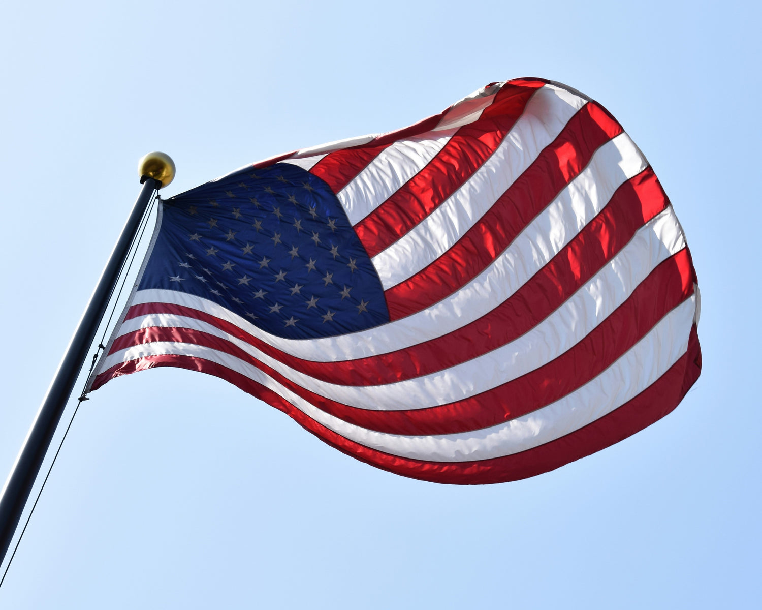 An American flag flying on a flagpole.