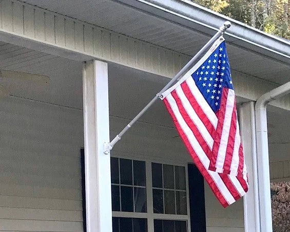 A porch flag and pole set with an American flag.