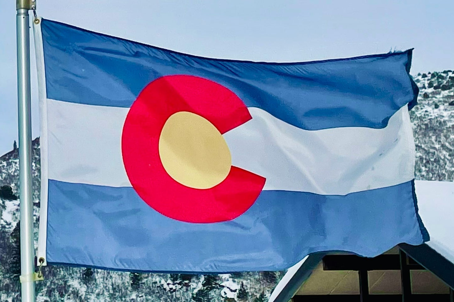 The flag of Colorado flying from a flagpole.