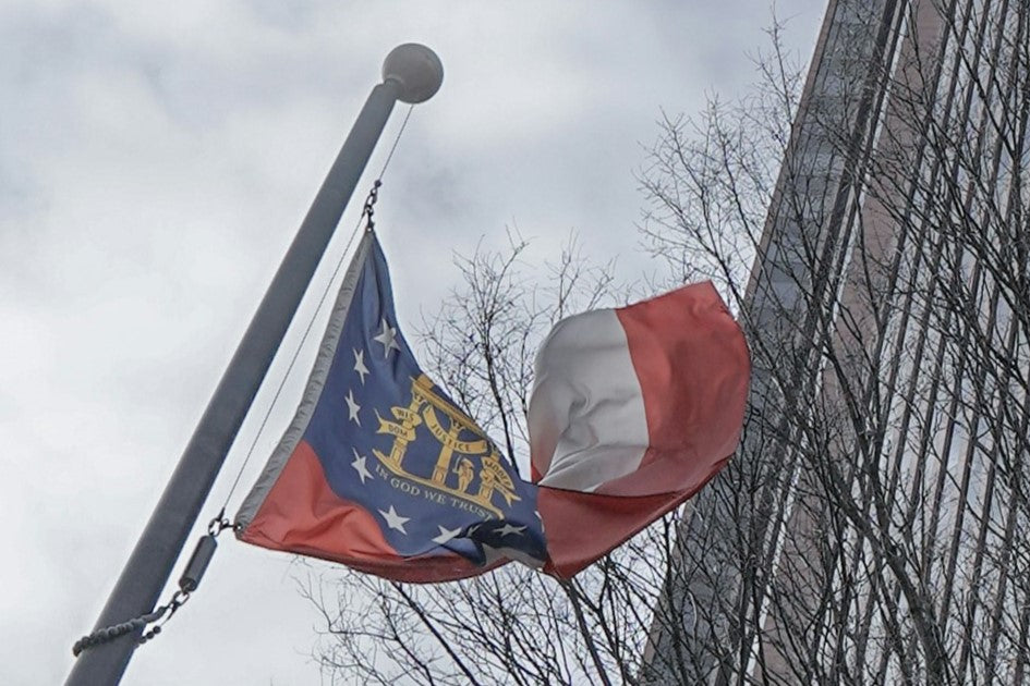 A flag of the state of Georgia flying on a flagpole.