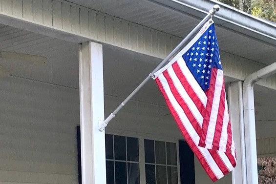 American flag and pole attached to a porch